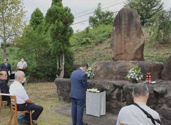  参加祭典的人在纪念碑前悼念死者。图源：《京都新闻》