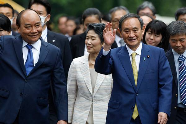 当地时间2020年10月19日，越南河内，越南总理阮春福（左）欢迎来访的日本首相菅义伟和夫人。人民视觉  图