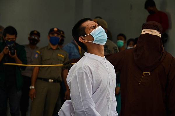 当地时间2021年1月28日，印度尼西亚班达亚齐，一名被控有同性性行为的男子被伊斯兰教法警察用藤条鞭打。人民视觉  图