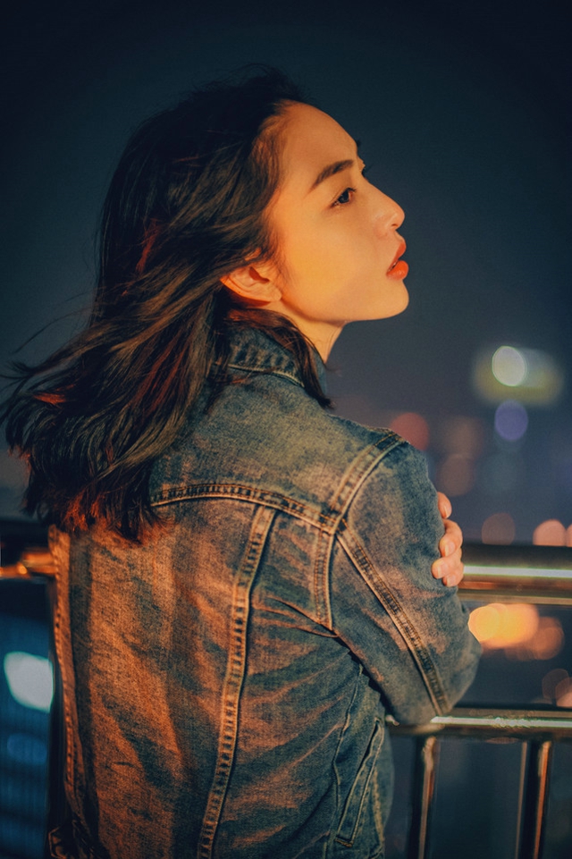 高楼上的咬唇颓废美女牛仔背心隐约现乳沟