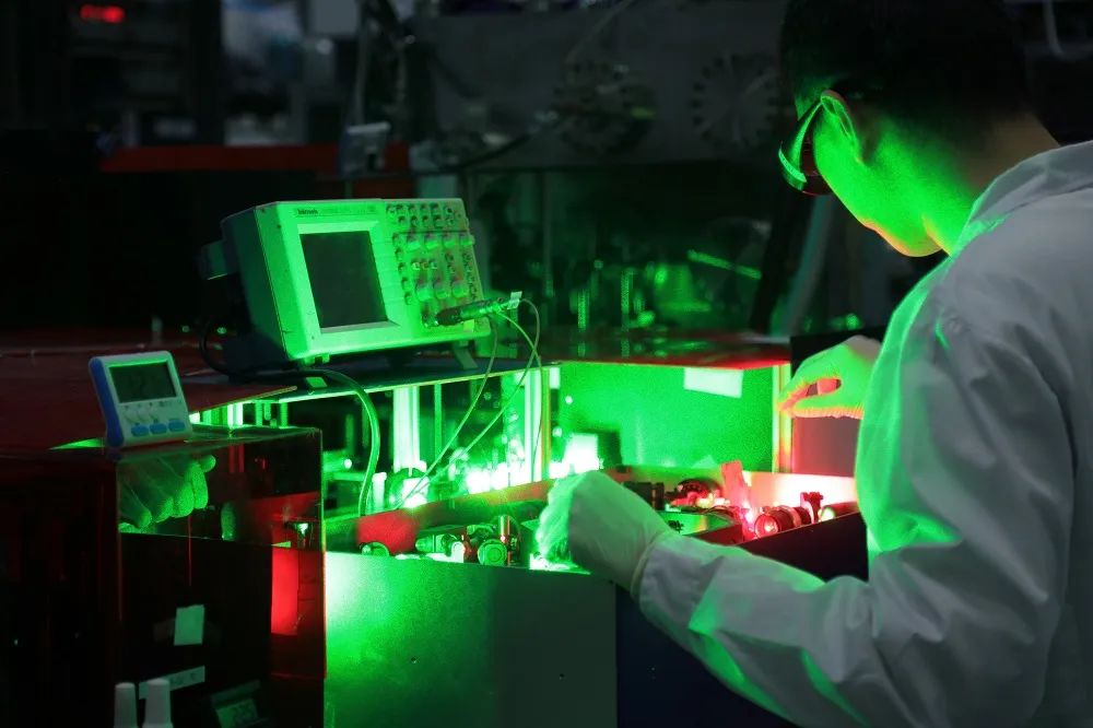 研究人员在控制氢分子化学键取向的激光器前工作。图片来源:中科院大连化物所