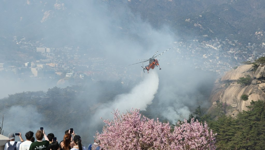 4月2日,位于首尔市钟路区的仁王山发生山火,消防直升机正开展灭火工作。 图源:韩联社