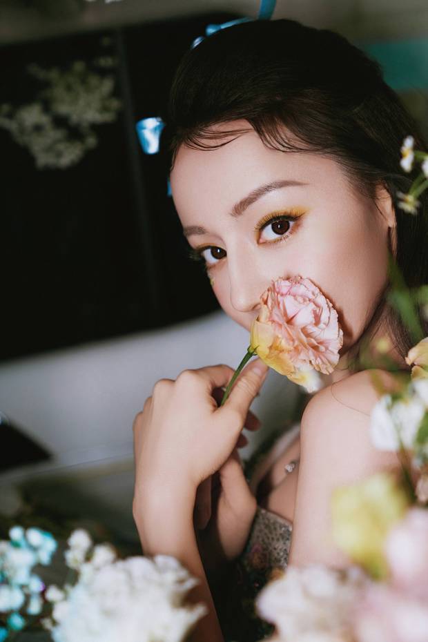 迪丽热巴身穿花裙甜笑明艳大方 嘴含花瓣酷似神女