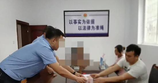 民警将追回来的9万元钱交给杨先生的亲属
