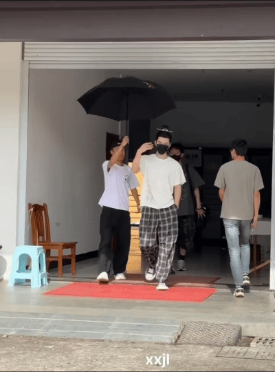 何与拍开工作人员撑的伞引争议 被网友怒斥没礼貌