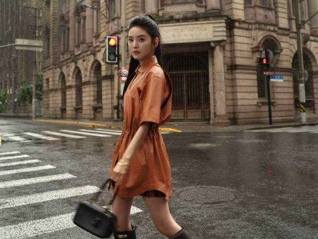 章若楠穿橘色皮裙漫步上海 手撑雨伞步伐轻盈灵动