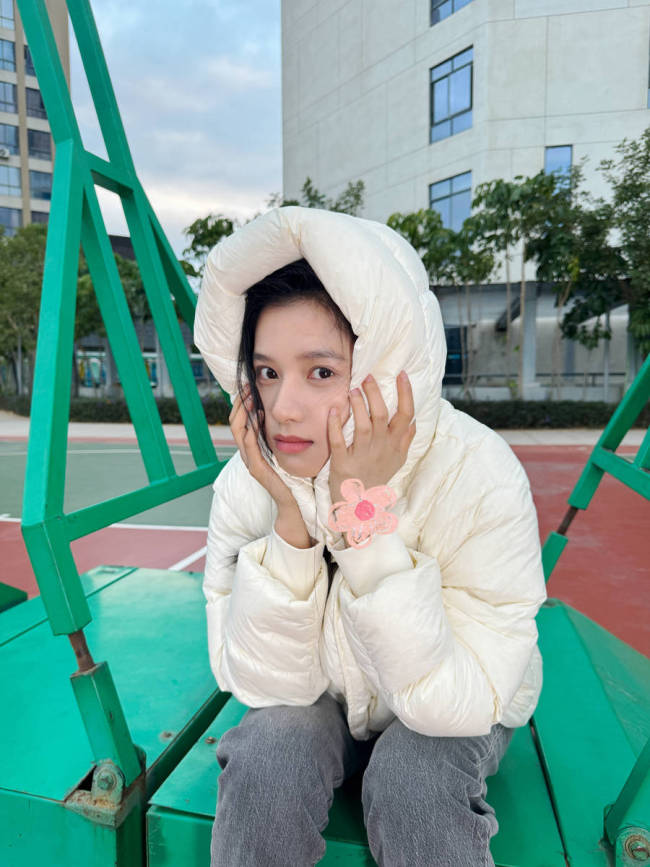 张婧仪身穿羽绒服笑容灿烂 双手托腮显俏皮