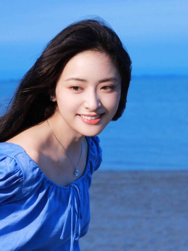 沈月穿蓝色连衣裙海边拍照 笑容甜美氛围感拉满